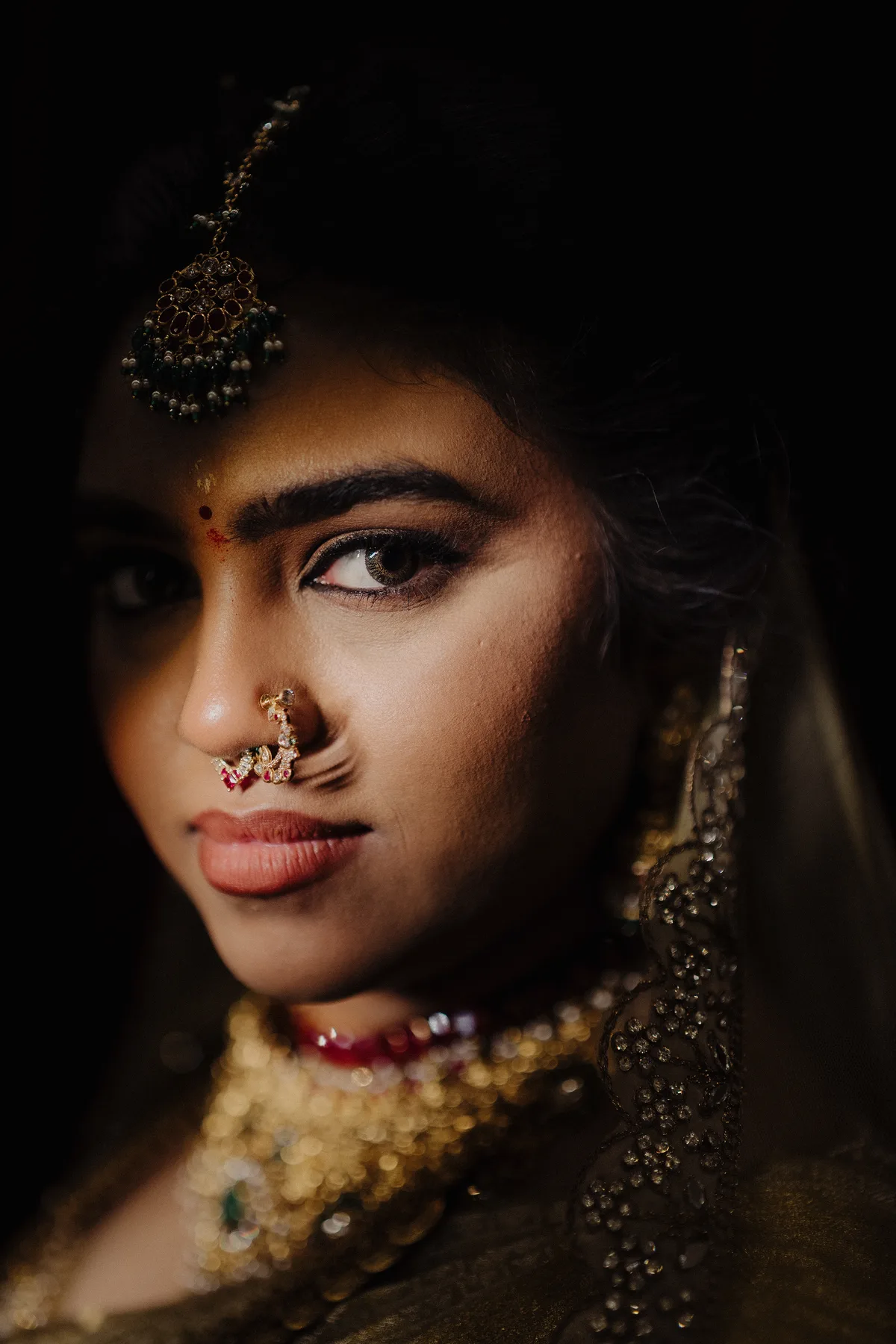 Close portrait of a bride wearing gold jewellery